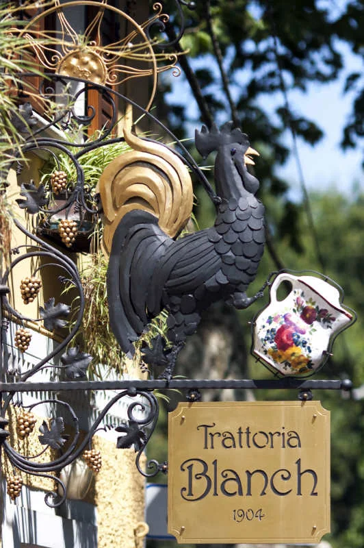 Il gallo e l'insegna originale della Trattoria Blanch